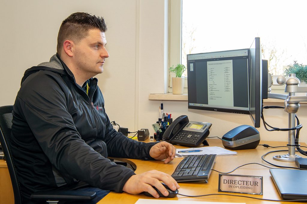 Donny Drevers aan zijn bureau op het kantoor van Car Concern