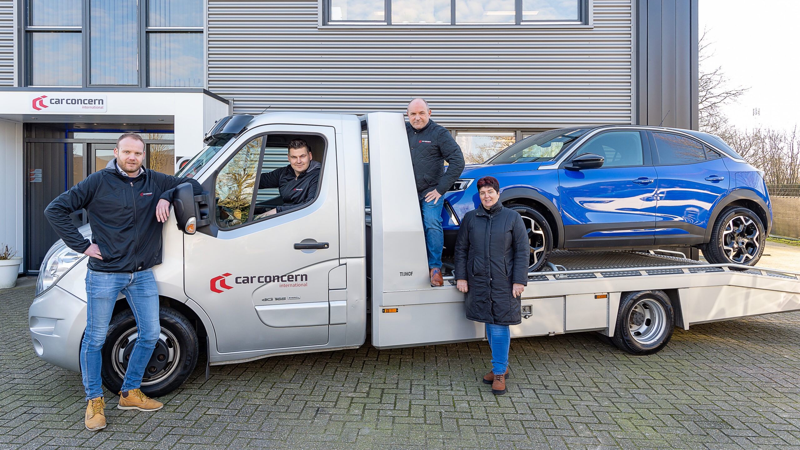 Het team van Car Concern International bij de eigen oprijwagen voor het pand